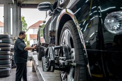 A member of the TAC team working on a wheel alignment